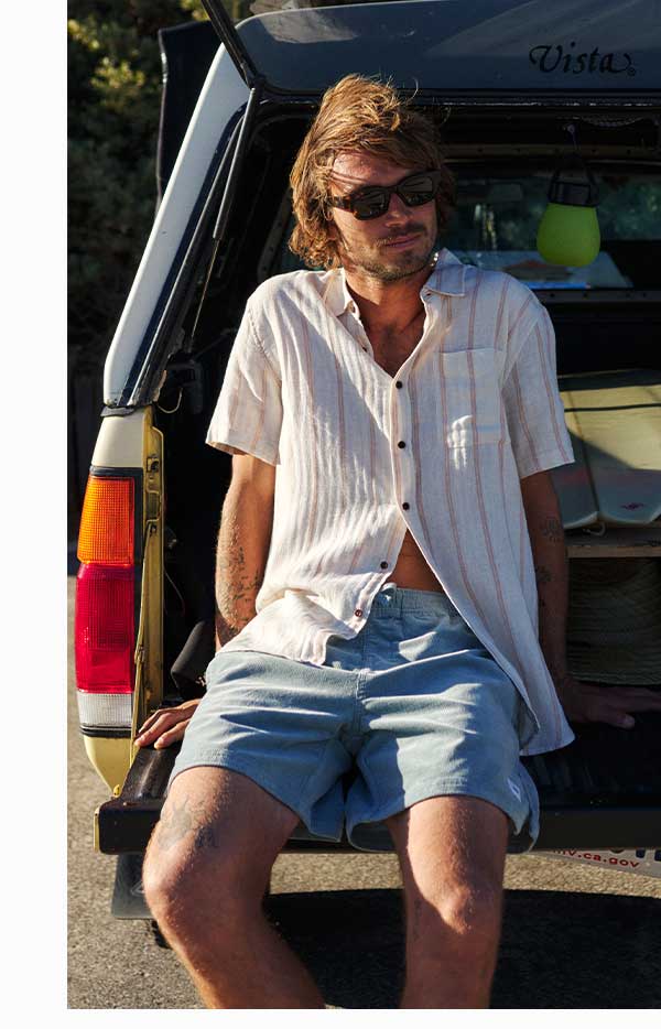 Model sitting on truck bed wearing Kord Patio Shorts