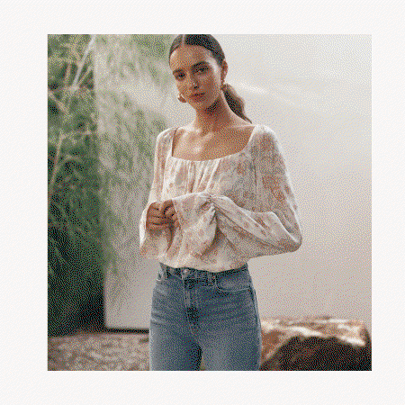 Animated images rotating between a woman wearing a floral blouse and light wash jeans, tan suede loafers, and a white embroidered denim jacket on a wicker chair.