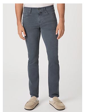 A man's legs wearing a pair of steel blue denim jeans with light tan suede loafers.