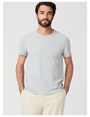 A man wearing a light blue t-shirt paired with light cream colored linen shorts.