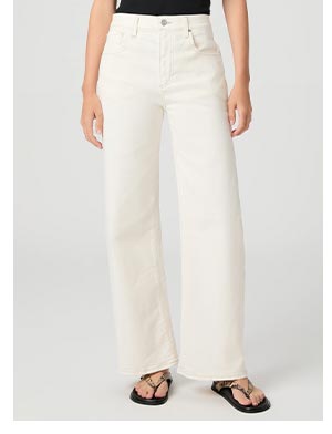 Image of woman's legs wearing white denim jeans and black sandals.