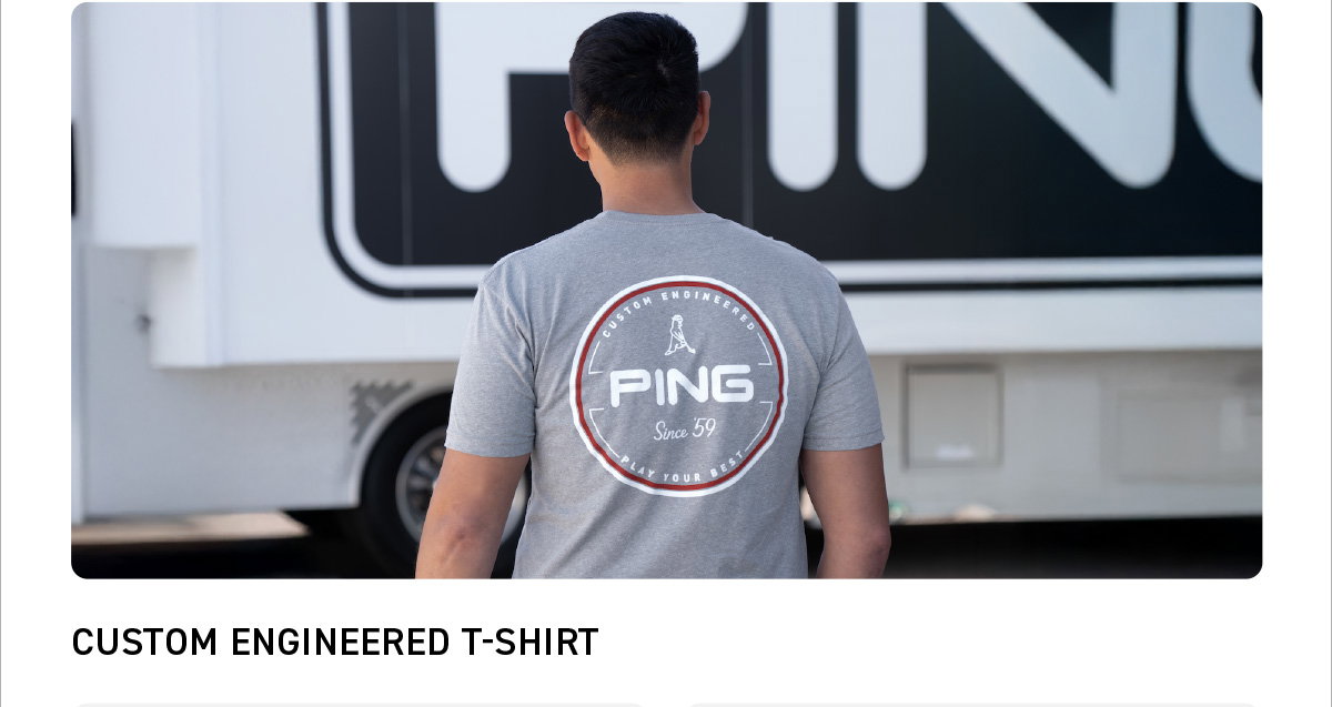 Back image of a male model wearing the Custom Engineered T-shirt in Dark Heather Grey.Text reads: Custom Engineered T-shirt. Click to SHOP NOW.