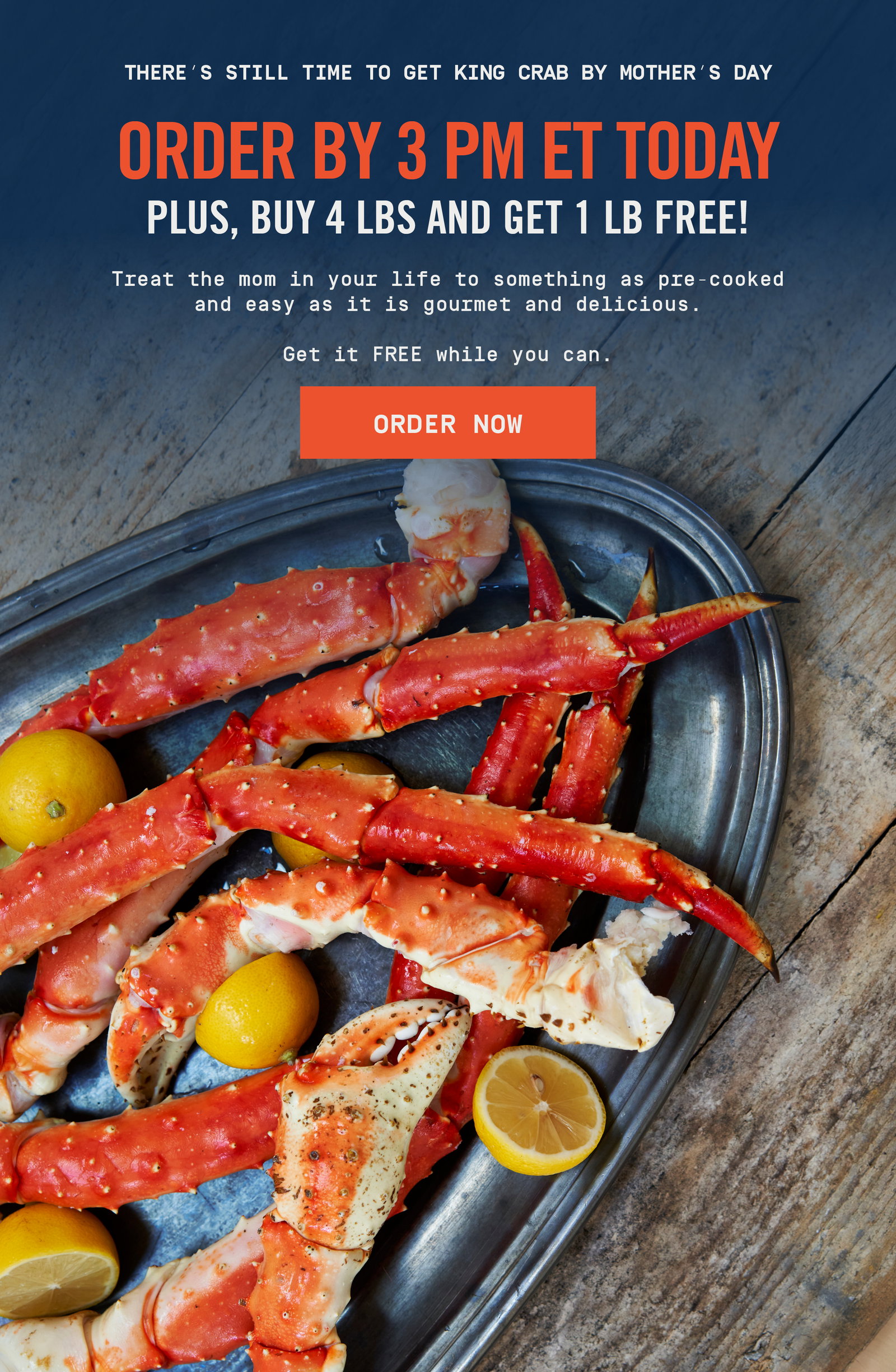 Cooked king crab legs arranged on a metal tray with lemons.
