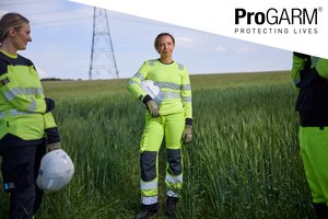 Image of 2 ladies wearing flective workwear and holding white hard hats