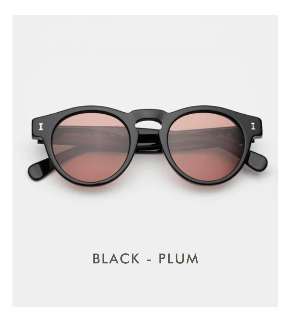 A studio product shot of the Leonard sunglasses in Black with Plum lenses. The frames are solid polished black with dark reddish-pink tinted lenses.