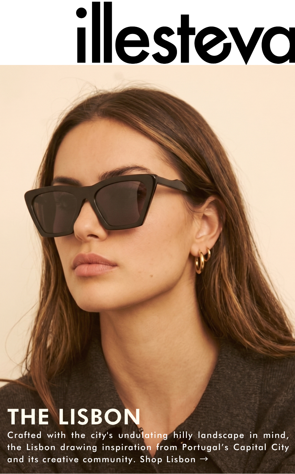 A lifestyle photograph featuring a woman wearing the Lisbon sunglasses in black. The frames are a bold, angular cat-eye shape. She is wearing gold hoop earrings and a charcoal grey knit sweater. The text at the bottom reads: 