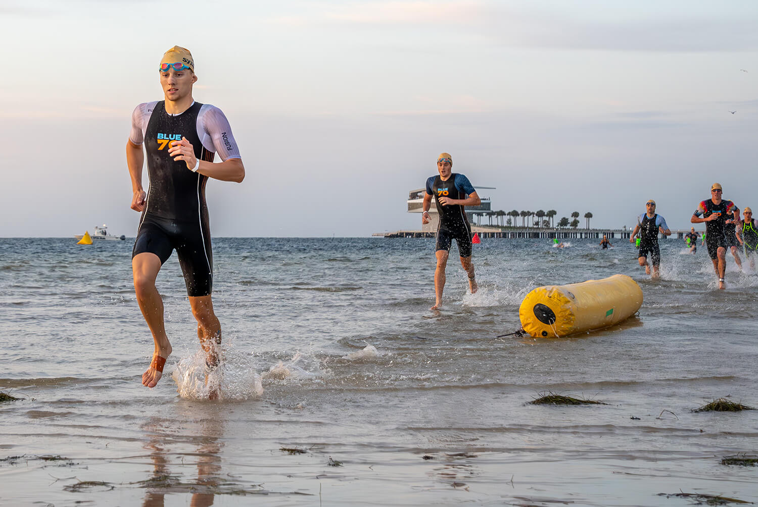 swimmer in new helix wetsuit adjusts goggles