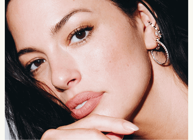 Model Ashley Graham wearing gold diamond jewelry. 