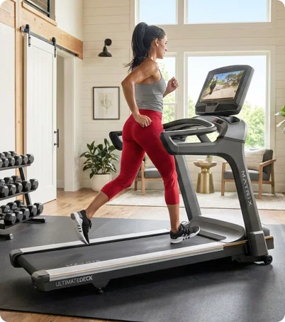 Woman in red leggings running on Matrix Treadmill in home workout room