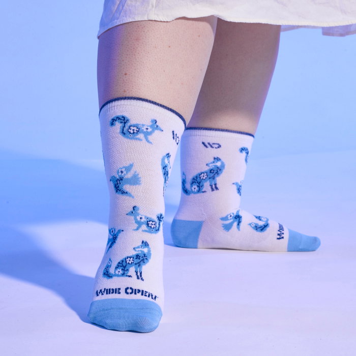 Shop the Woodland Wonder sock - a white crew sock with blue porcelain-inspired critters