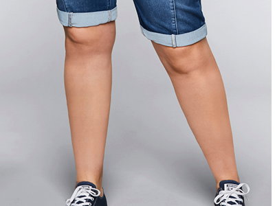 Model in knielanger Jeans mit umgeschlagenem Saum