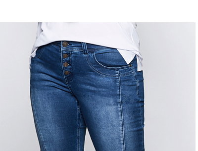 Model in knielanger Jeans mit umgeschlagenem Saum