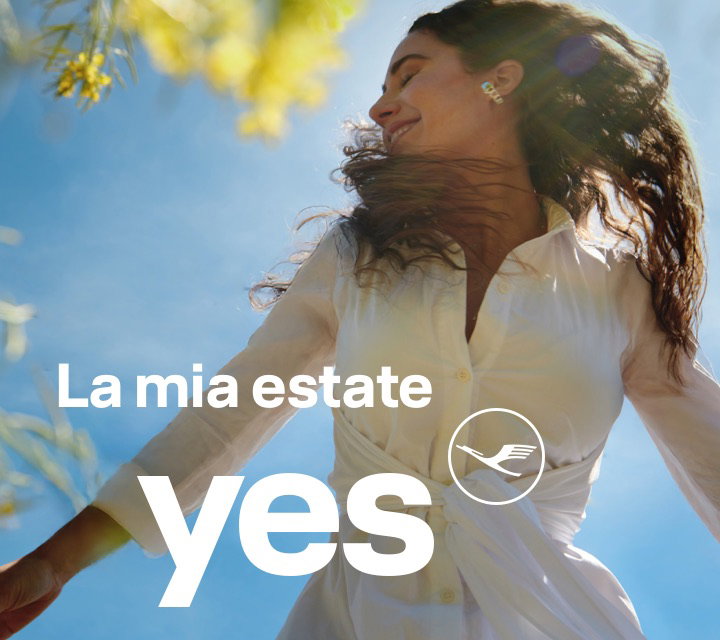 Puro feeling estivo – donna con le braccia aperte che si gode il sole sotto un cielo blu