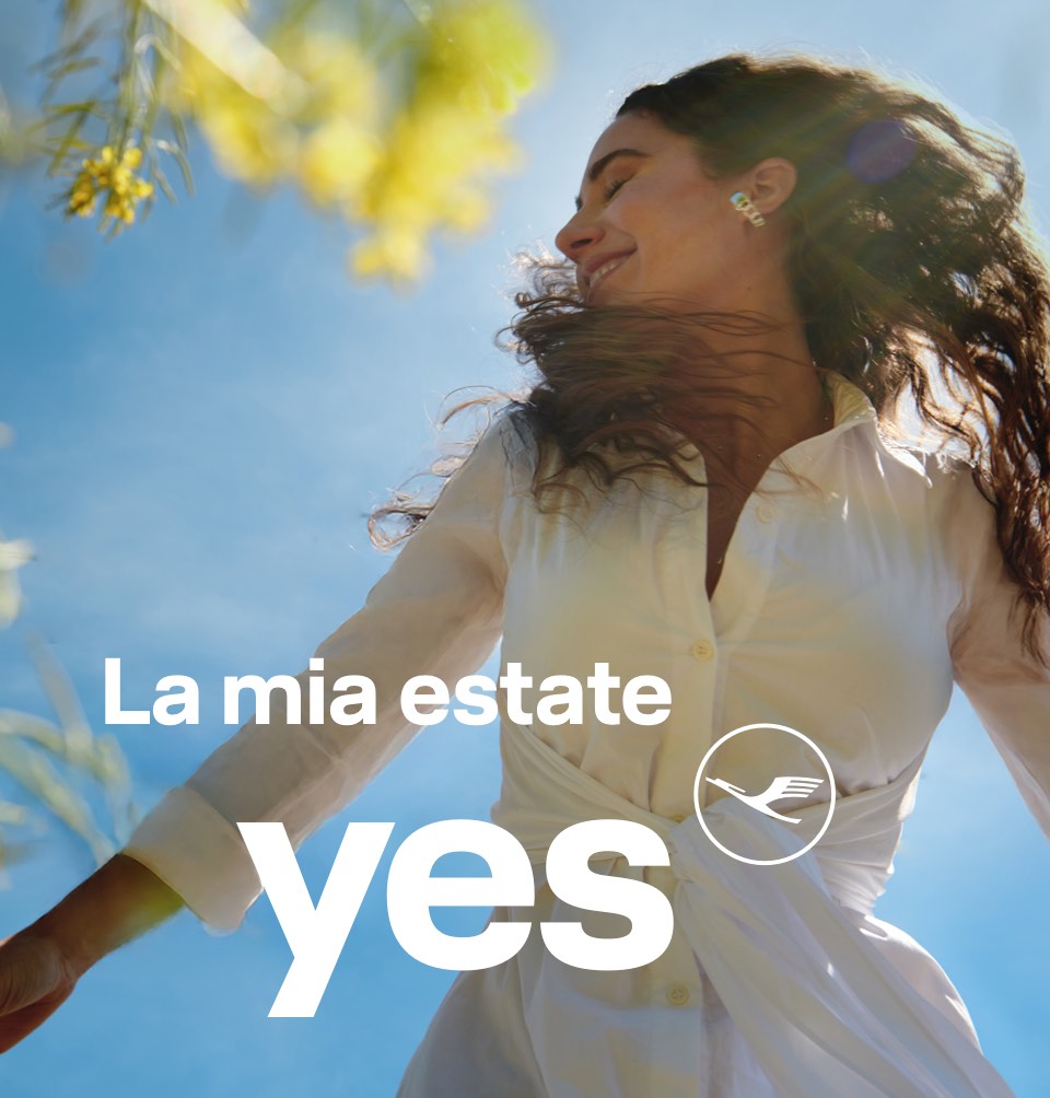 Puro feeling estivo – donna con le braccia aperte che si gode il sole sotto un cielo blu