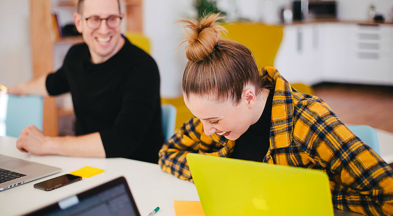 Two people having fun while working in front of a desk