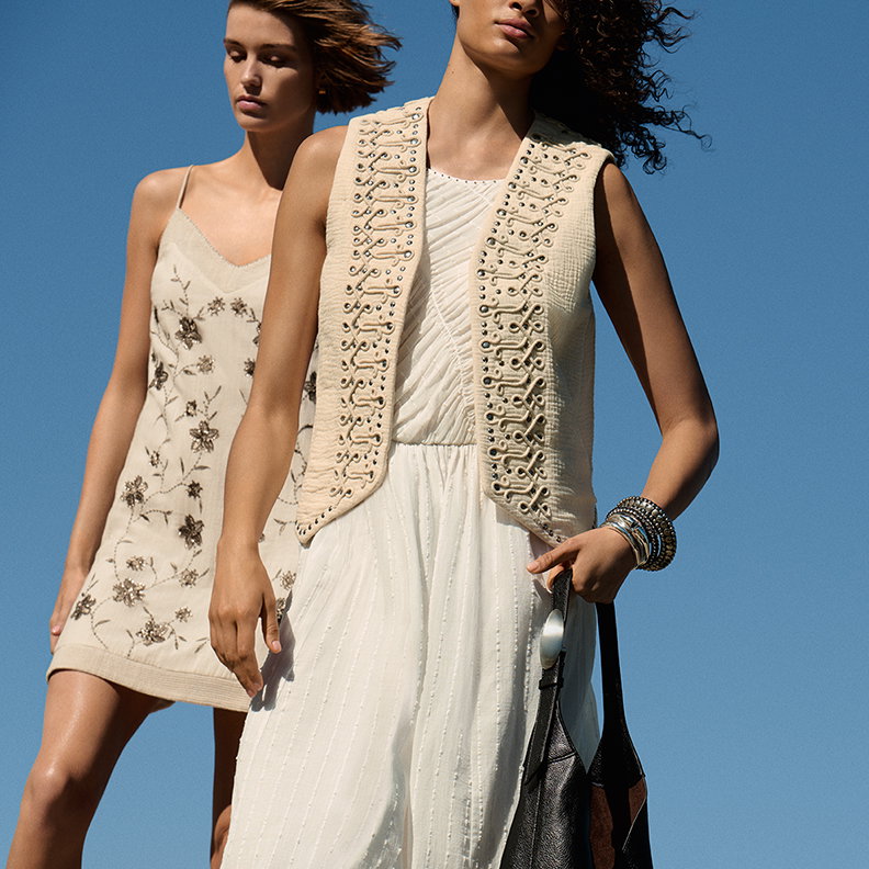 Two women wearing Pure Cotton Embellished V-Neck Mini Cami Dress in Soft White and Pure Cotton Studded Gilet in Ecru