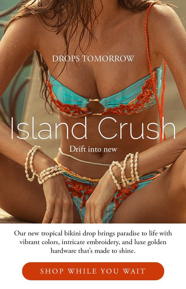 Drops Tomorrow. Island Crush. Model wearing a blue and orange bandeau style bikini with gold hardware. 