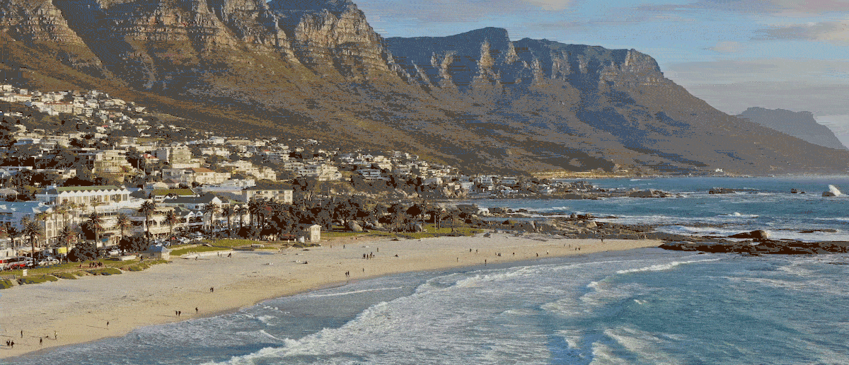 Blick auf Strand, Tafelberg und Häuser von Kapstadt an einem sonnigen Tag.