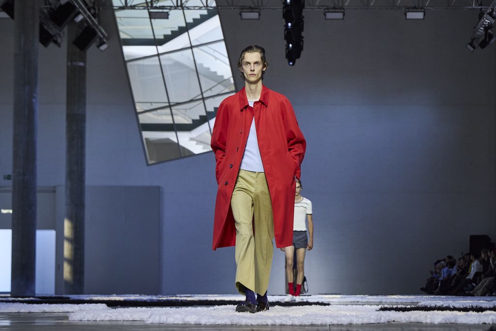 Model wears red Prada raincoat