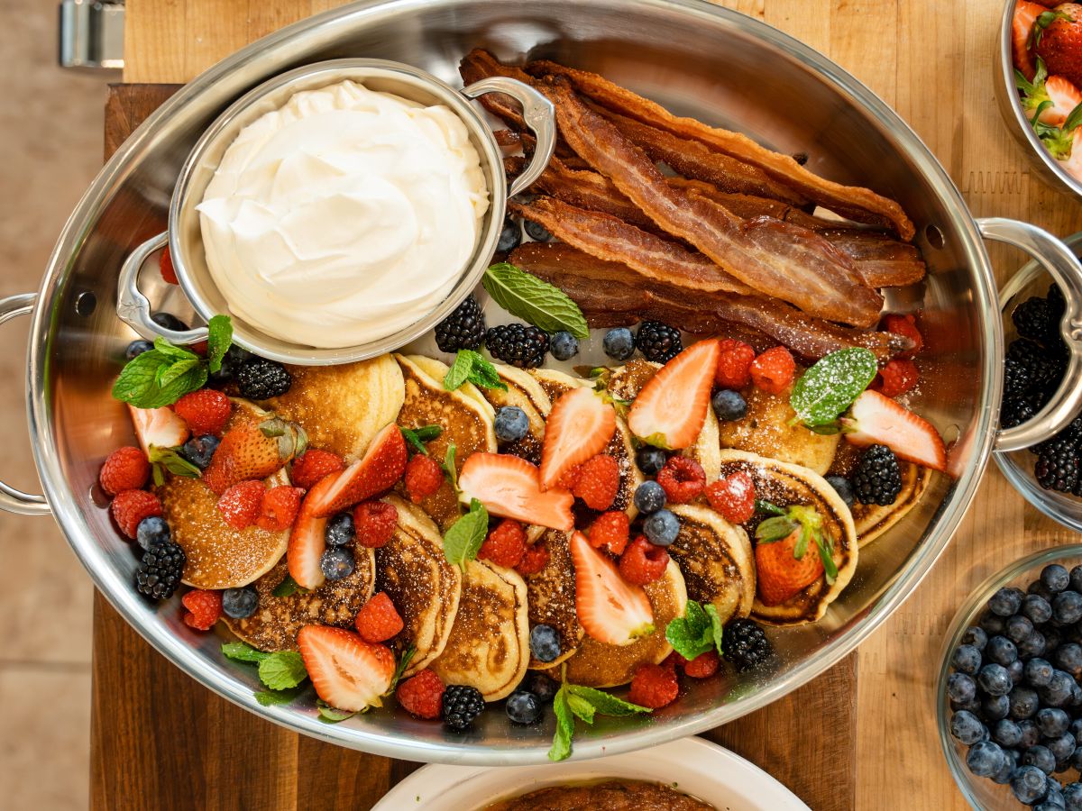 IMG: Pancakes, bacon, dip, and various berries on a Hestan Large Oval Roaster