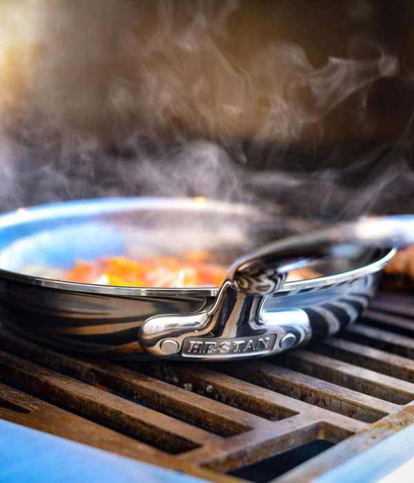IMG: Shrimp cooked in NanoBond skillet, with sides and glasses of wine, displayed on marble countertop
