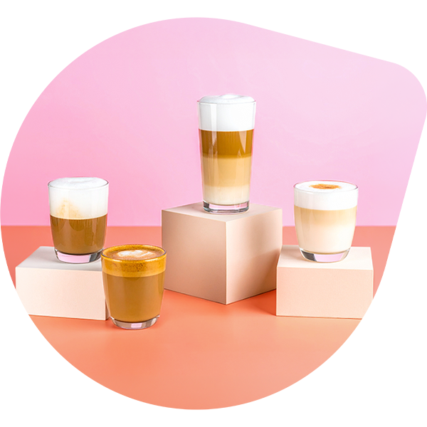 Cuatro cafés en vasos sobre una mesa de cocina