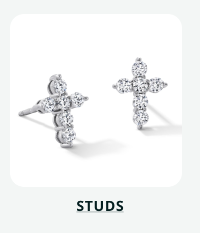 Pair of silver cross shaped studs encrusted with round cut diamonds. Click here to shop studs