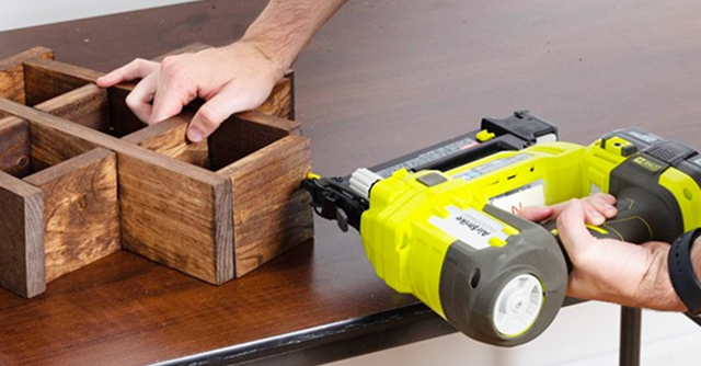 A pair of hands assembling wood with a power tool