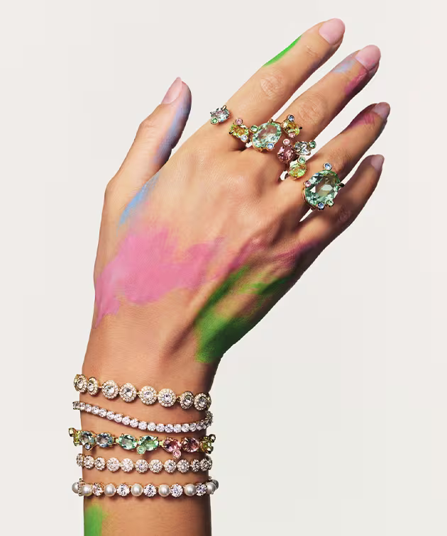 Hand model wearing multiple Swarovski bracelets