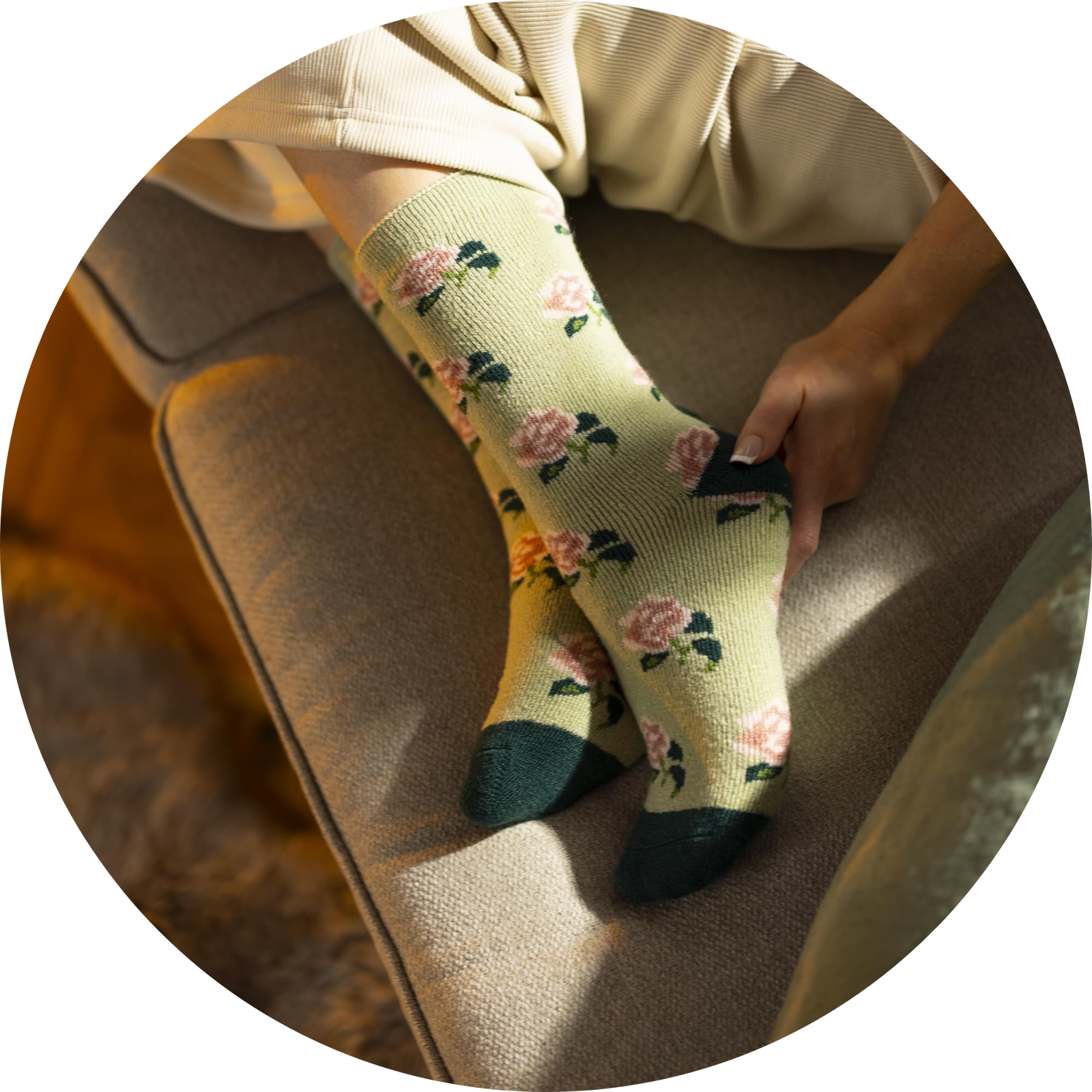 Person relaxing on a chair wearing cream-colored socks with a pink floral pattern: Women's LITE RHS Roses Crew Sock Sage.