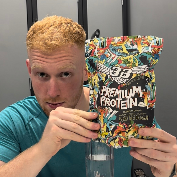 man holding a pack of premium protein powder
