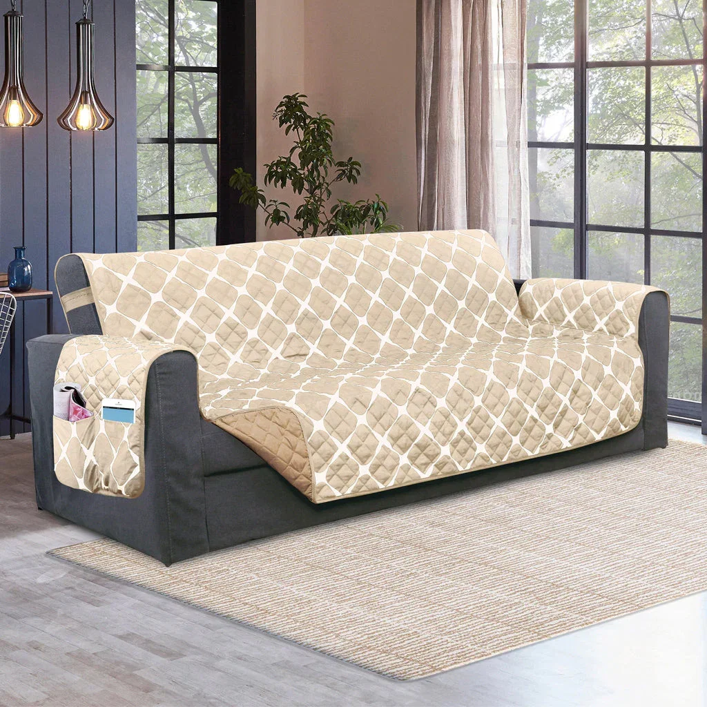 Beige quilted sofa protector with geometric pattern on dark gray couch in modern living room with large windows