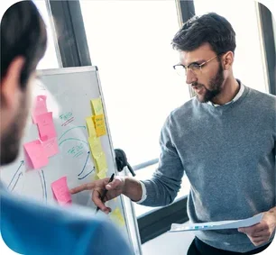 image-person-pointing-at-sticky-note-on-whiteboard