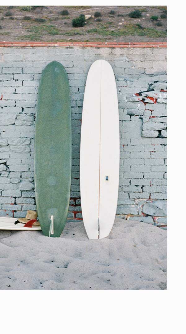 two surfboards leaning up against coastal wall