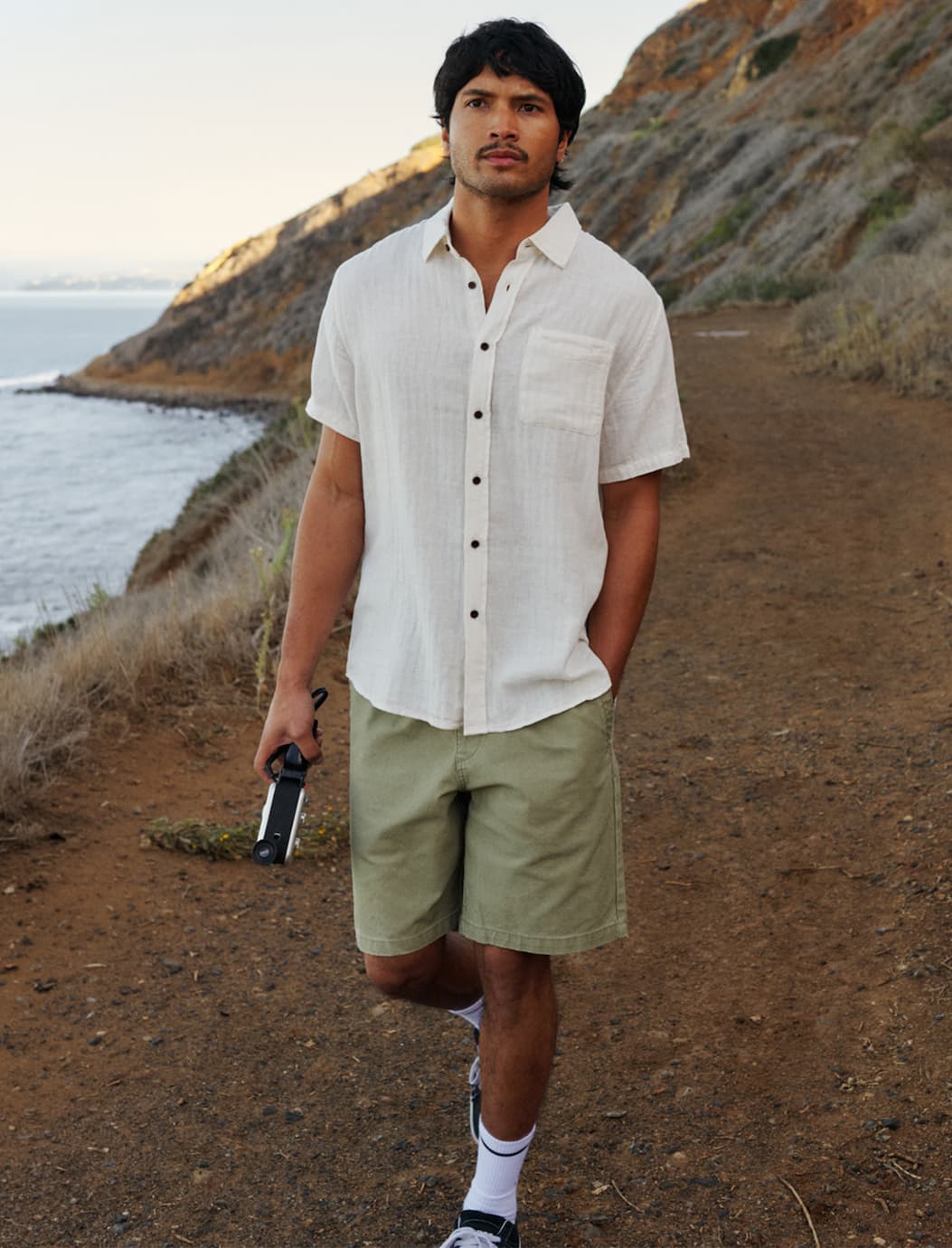 Male Model walking on coastal path in shorts and shirt