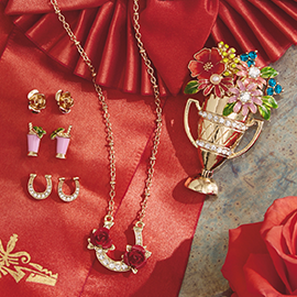 Jewelry laying on red ribbon.