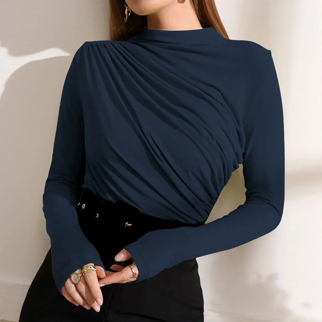 Woman wearing navy blue wrap top with long sleeves and black pants, styled with gold rings