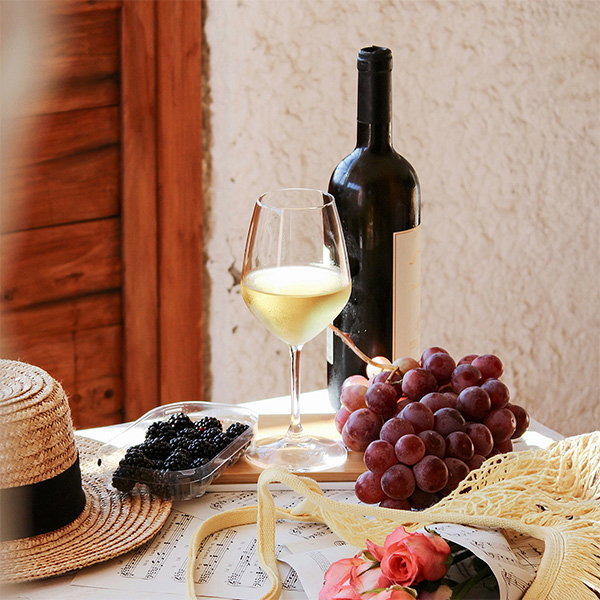 Weinflasche mit Weißwein, Trauben und Snacks