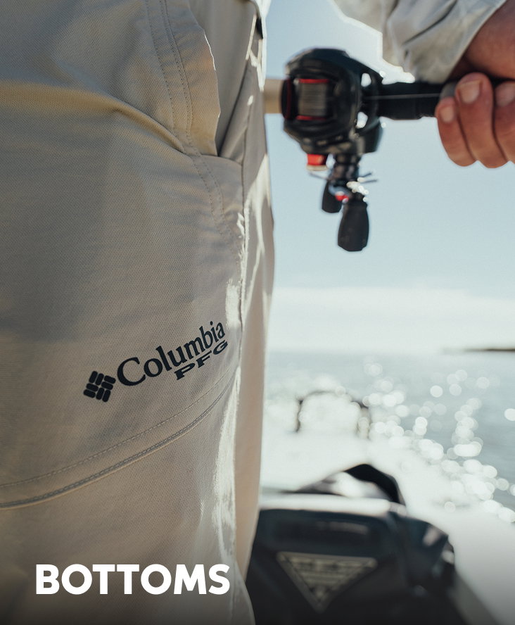 Close-up of an angler's tan pants with a Columbia PFG logo on the side, as they ride a boat with text: BOTTOMS