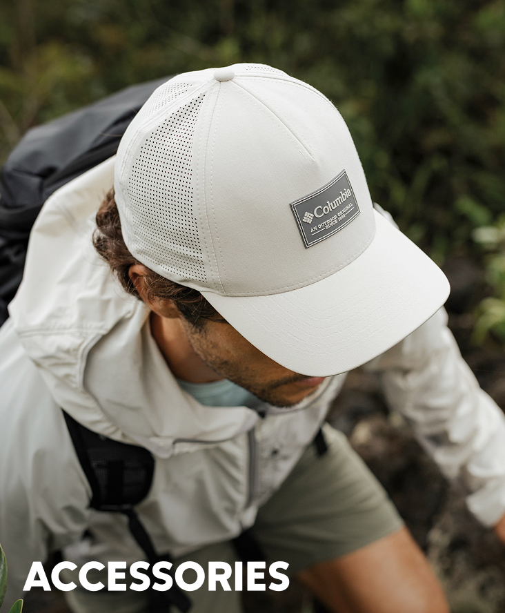 A man wearing a white ball cap out in the forest with text: ACCESSORIES