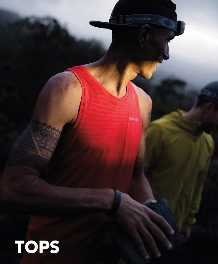 A man in a red tank top, out in the desert with text: TOPS