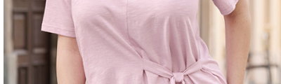 Ein Model trägt ein rosé farbenes Shirt mit Bindebändern. Daneben folgender Text: Shirts so vielseitig wie du
