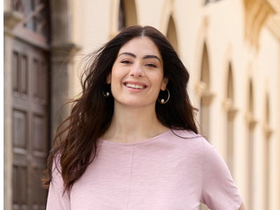 Ein Model trägt ein rosé farbenes Shirt mit Bindebändern. Daneben folgender Text: Shirts so vielseitig wie du