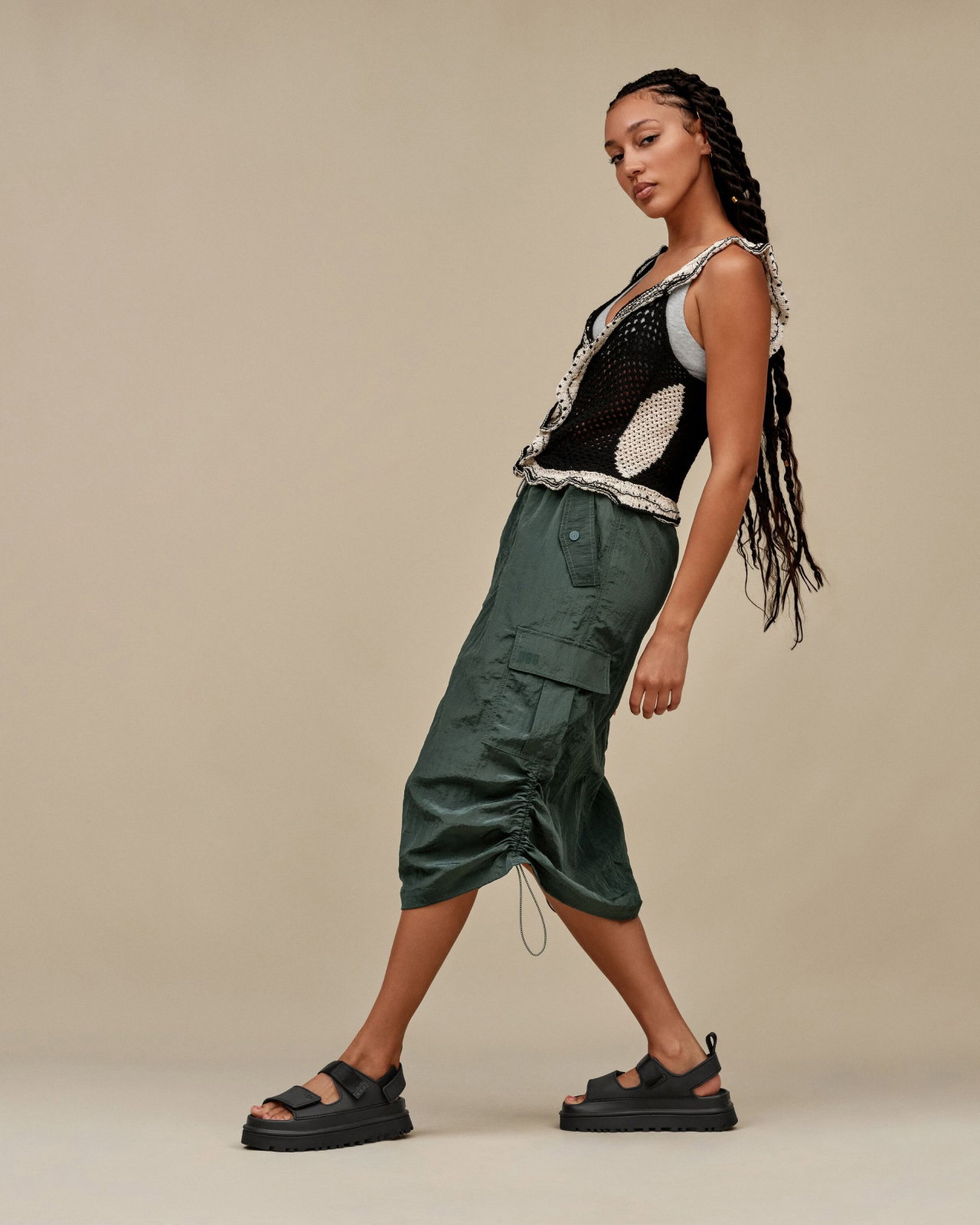 A studio shot of a model wearing the Goldenglow Sandals