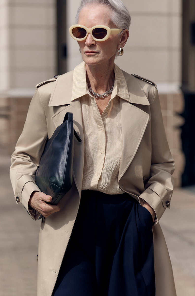 Woman wearing Cotton Rich Trench Coat in Neutral and carrying Black Top Handle Shoulder Bag