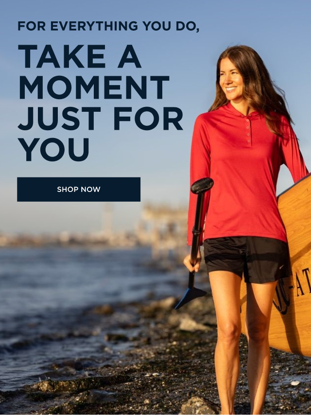 Smiling woman walking on the beach with a paddle board and oar | Shop Now