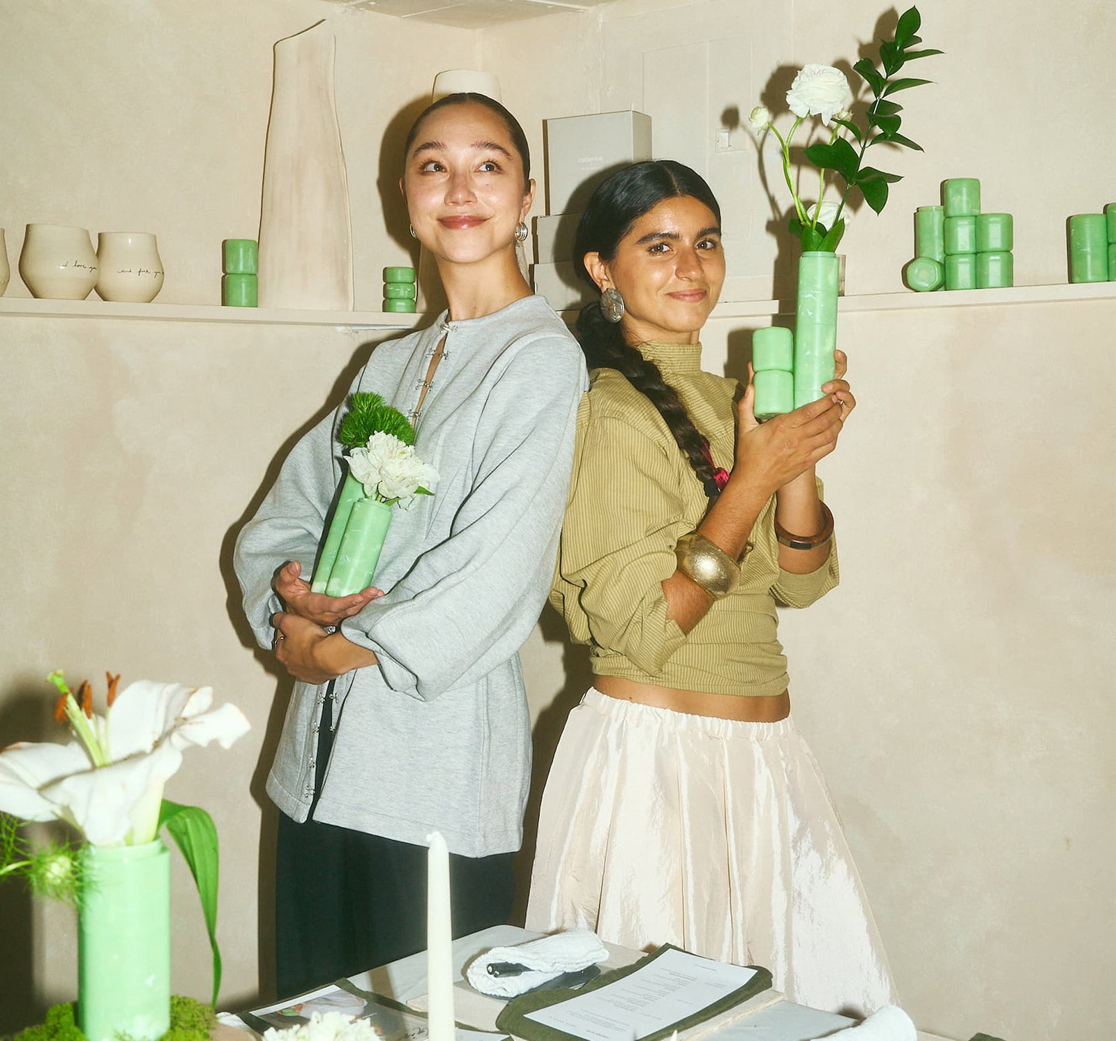 Click to shop The Jade Collection. Image of people holding Jade Capsules with flowers in them.