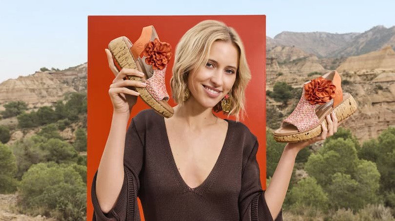 Women holding orange Rieker sandals