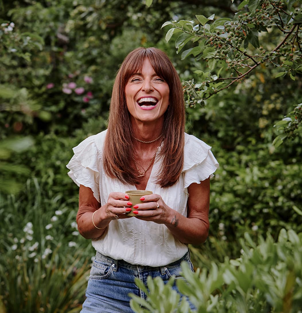 Davina McCall smiling and holding a mug.