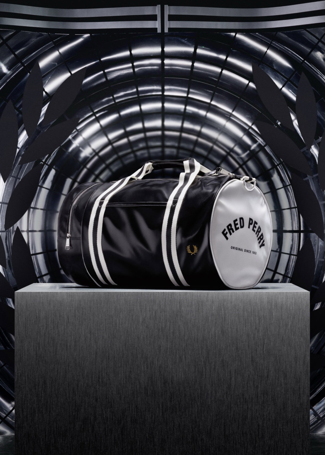 A photograph of our classic black and white barrel bag sitting on top of a podium